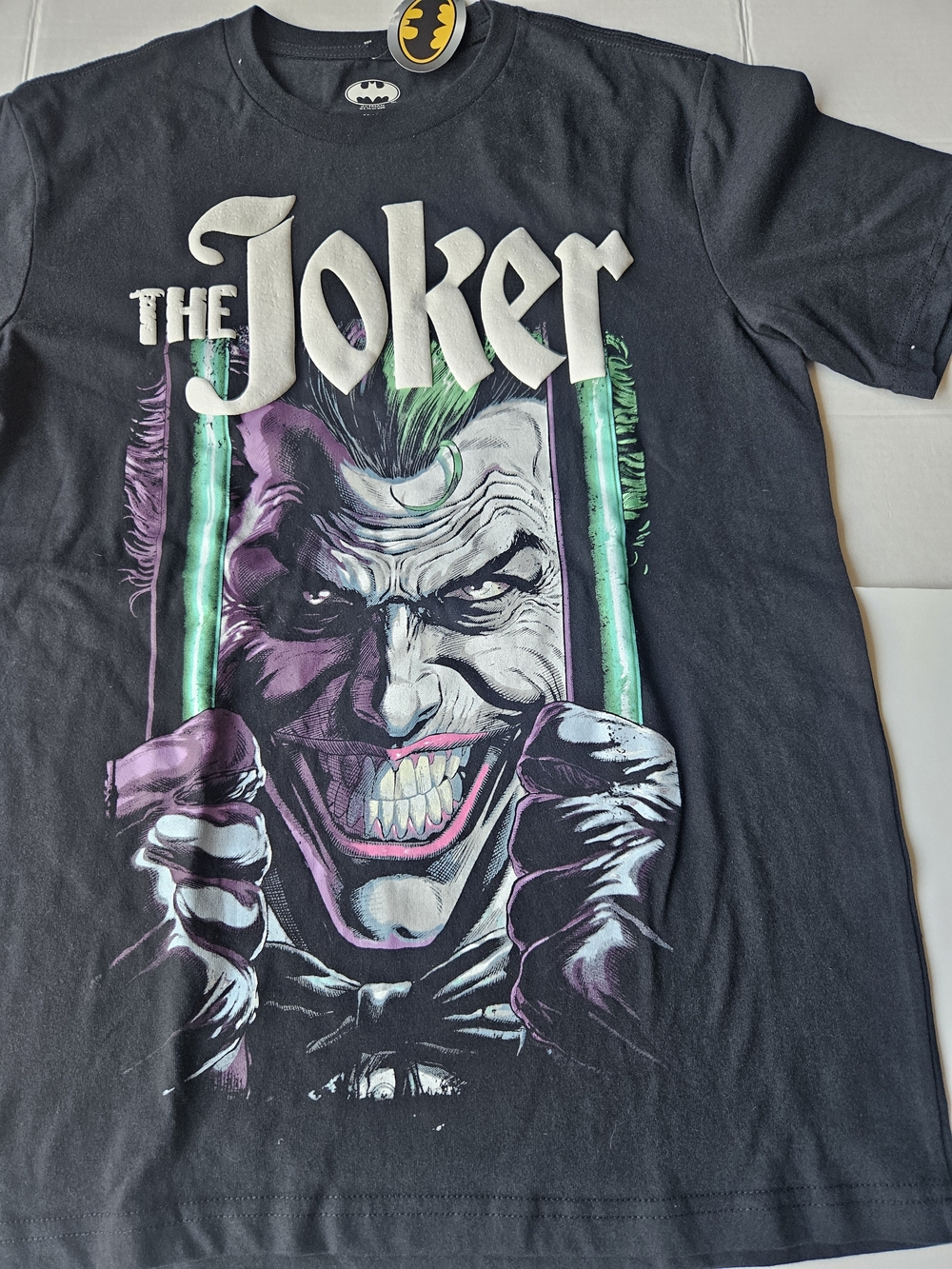 DC Comics graphic t-shirt featuring a stylized portrait of The Joker gripping Pr